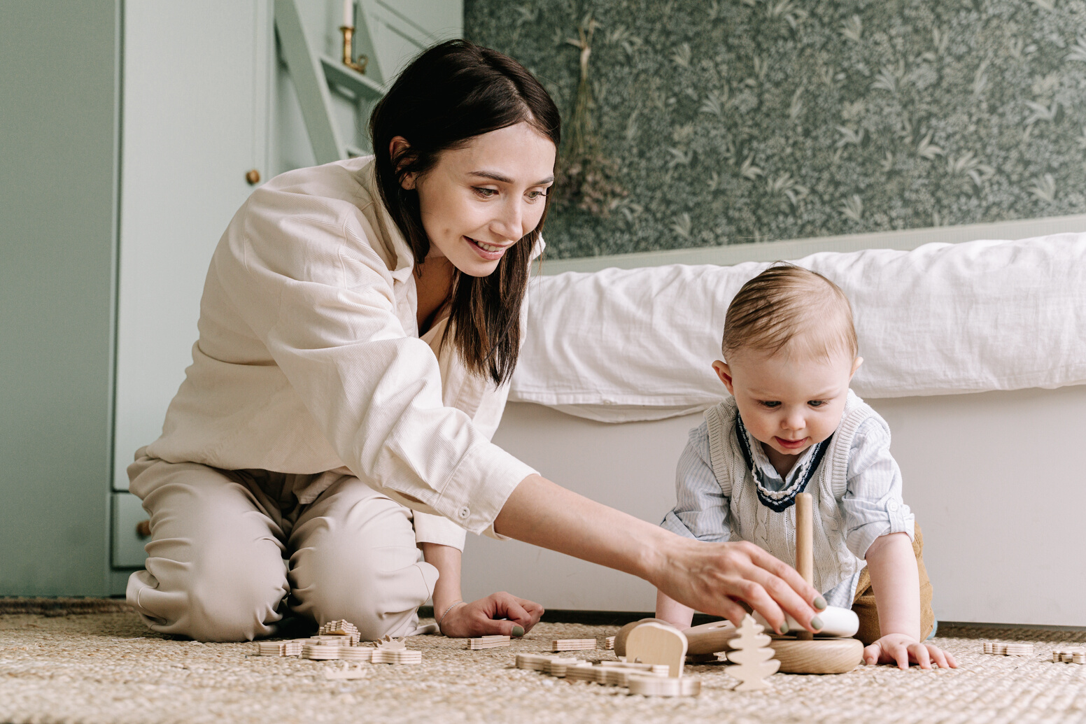 Mother and Baby Playing with Wooden Toy on the Floor